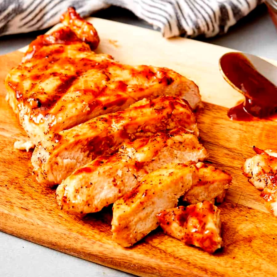 grilled chicken breast on a wooden board